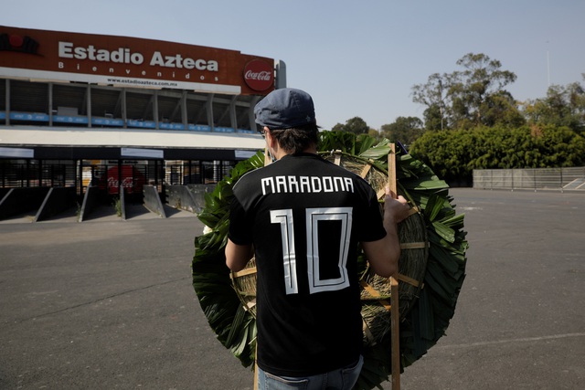  Một cổ động viên mang vòng hoa đến sân Atzeca để tri ân Maradona. Đây là sân đấu Maradona ghi 2 bàn thắng để đời, 1 bàn thắng 