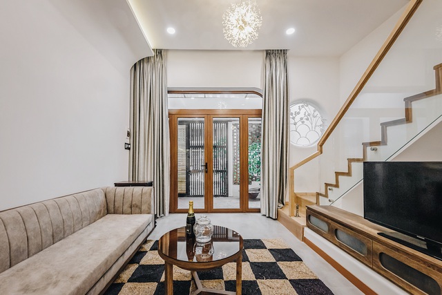 Phòng khách thể hiện đúng tinh thần phong cách tối giản với màu trắng của sơn tường và màu gỗ của nội thất. Sự kết hợp của những tông màu tương phản giúp ngôi nhà trông rộng rãi hơn mà vẫn ấm cúng, gần gũi.