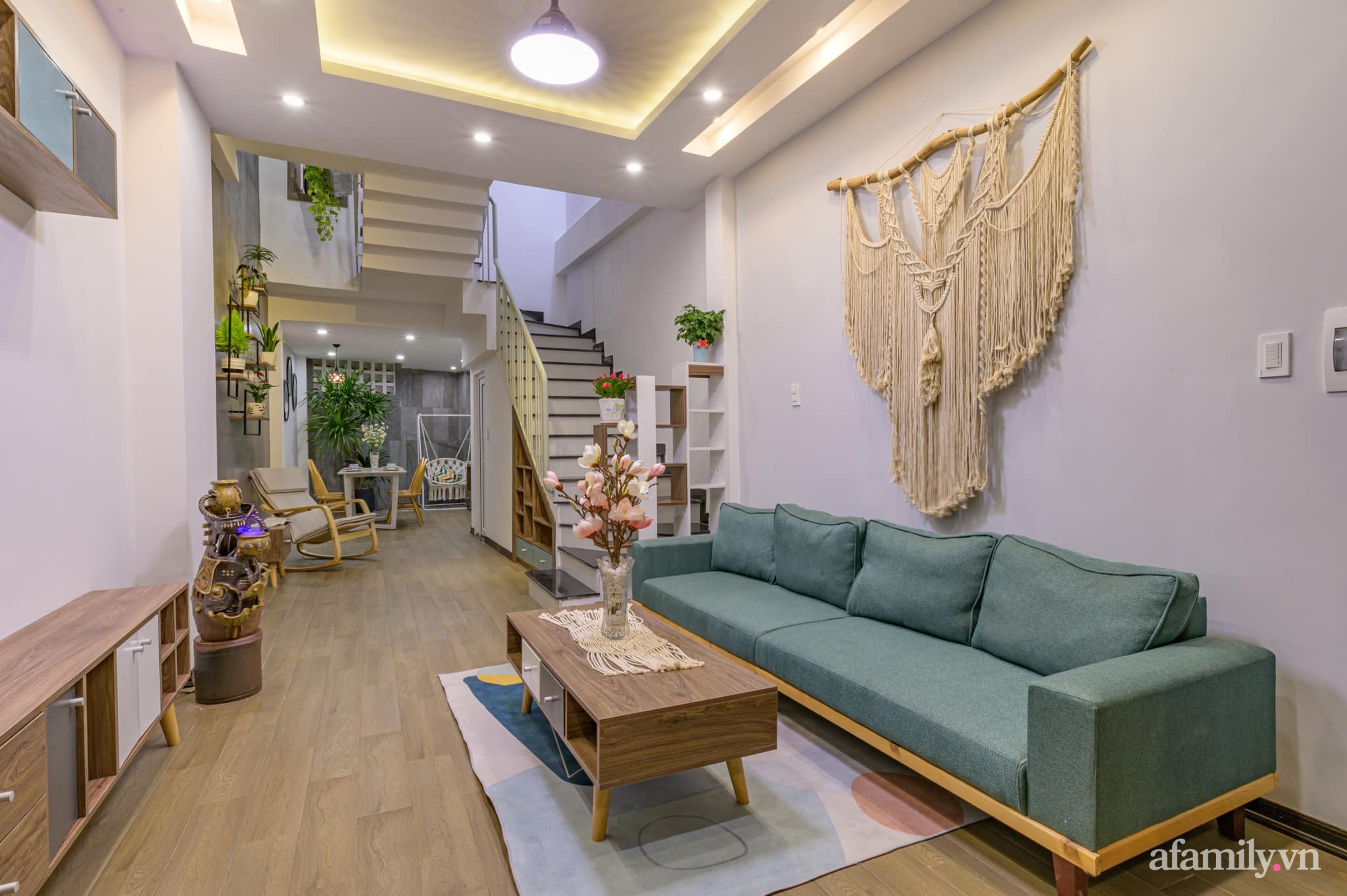  Không gian phòng khách với điểm nhấn từ màu xanh sofa. Góc nhỏ thân thiện đầy ấn tượng với nội thất gỗ và đồ trang trí treo tường.