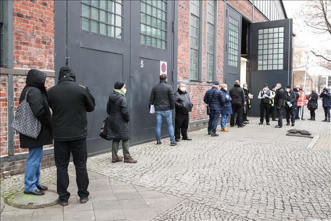  Người dân xếp hàng chờ tiêm vaccine phòng COVID-19 tại Berlin, Đức, ngày 27/12. Ảnh: THX/TTXVN