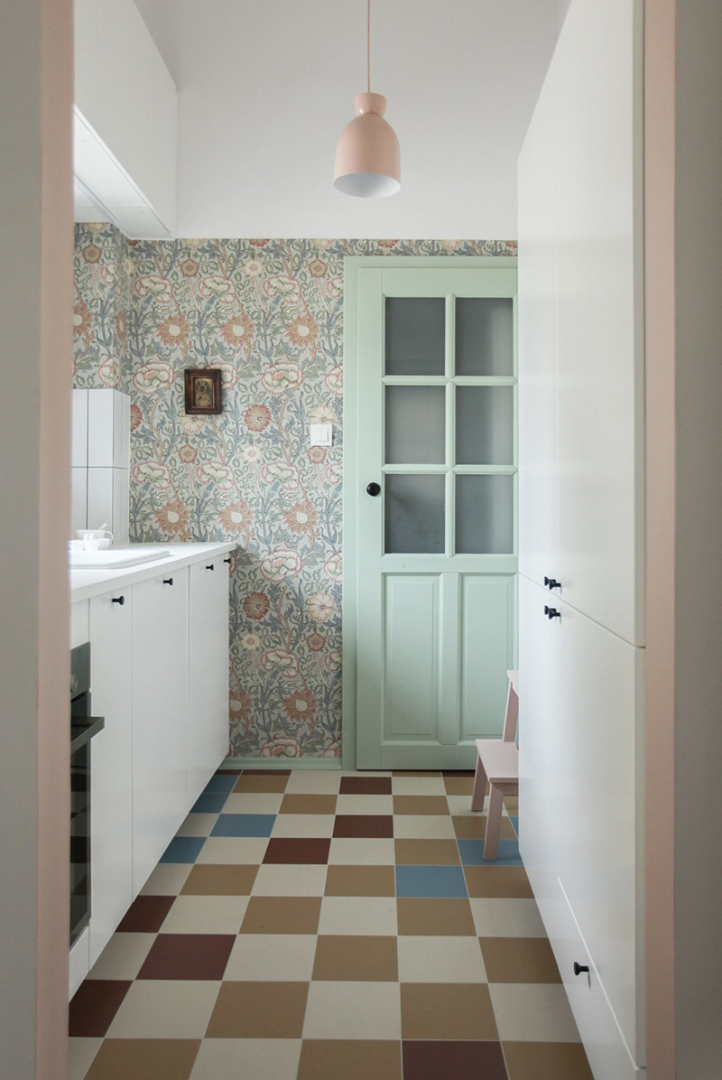  Có một căn bếp nhỏ được trang trí giấy dán tường Scandinavian, tủ kệ màu trắng và sàn lát gạch đầy màu sắc. Ảnh: @Polist Studio Morr.