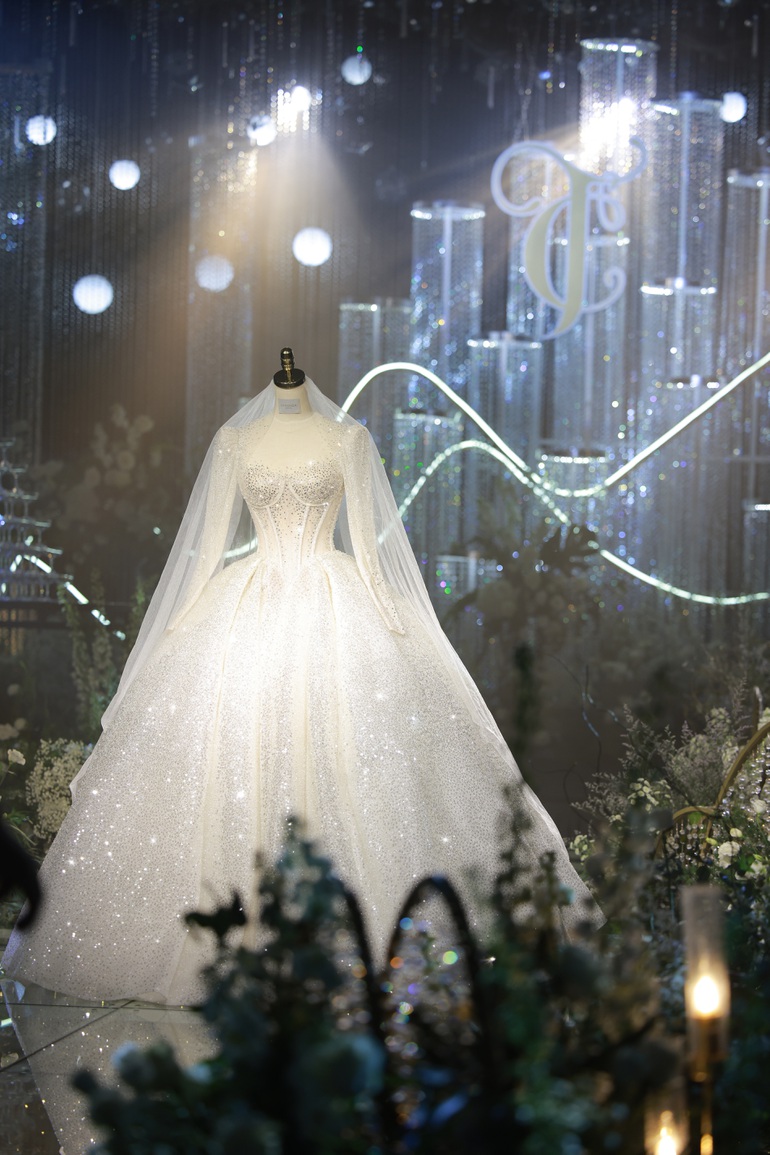  Theo như nhà thiết kế, hai mẫu váy cưới của cô dâu Mai Hà Trang đều được lấy cảm hứng từ vẻ đẹp cổ điển của thời Victorian kết hợp với sự hiện đại. Chiếc váy được dát nhũ ánh xà cừ nhập khẩu trực tiếp từ Ý, đính hơn 20.000 viên đá swarovski. 