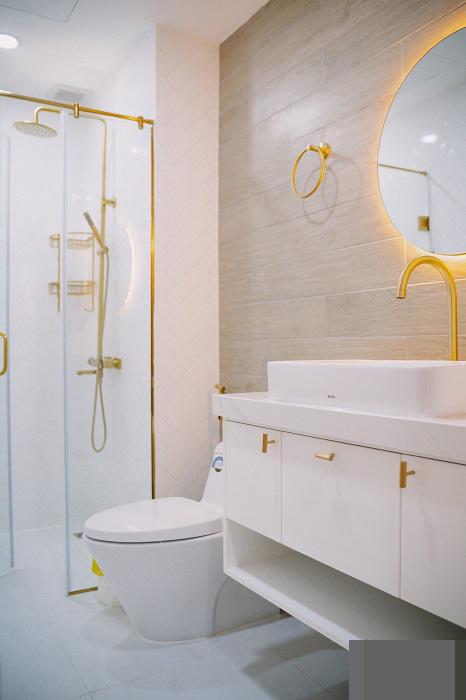  Phòng vệ sinh màu trắng nhã nhặn, các chi tiết mạ vàng nhấn nhá cho không gian thêm tinh tế, bớt đơn điệu.