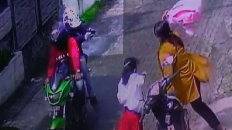  Người vợ bi hai gã đàn ông đi xe máy bắn bằng súng. Ảnh chụp từ video. 