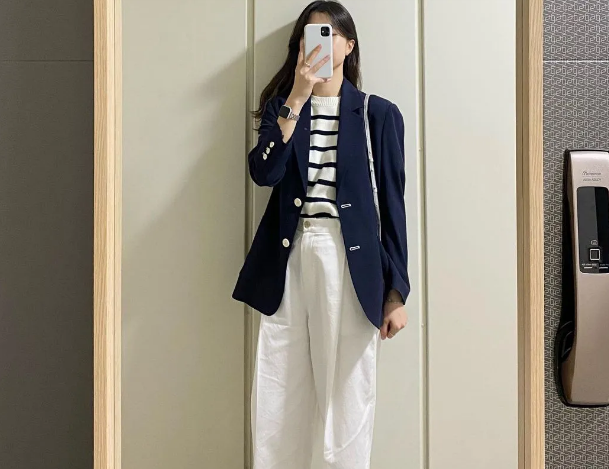  Chiếc blazer nghiêm túc sẽ trở nên trẻ trung và thú vị hơn đáng kể khi bạn học nàng blogger diện áo dệt kim kẻ ngang, quần vải trắng mix cùng blazer. 
