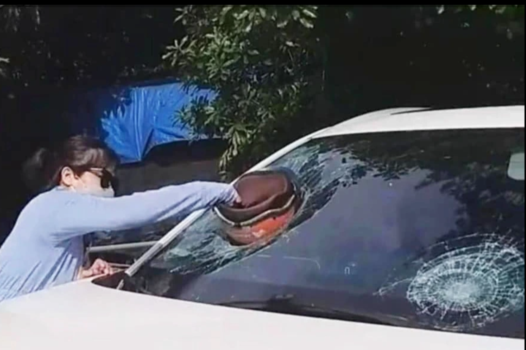  Hình ảnh người phụ nữ dùng mũ bảo hiểm đập vào kính xe ô tô nghi đánh ghen (Ảnh: Hoàng Bảo).