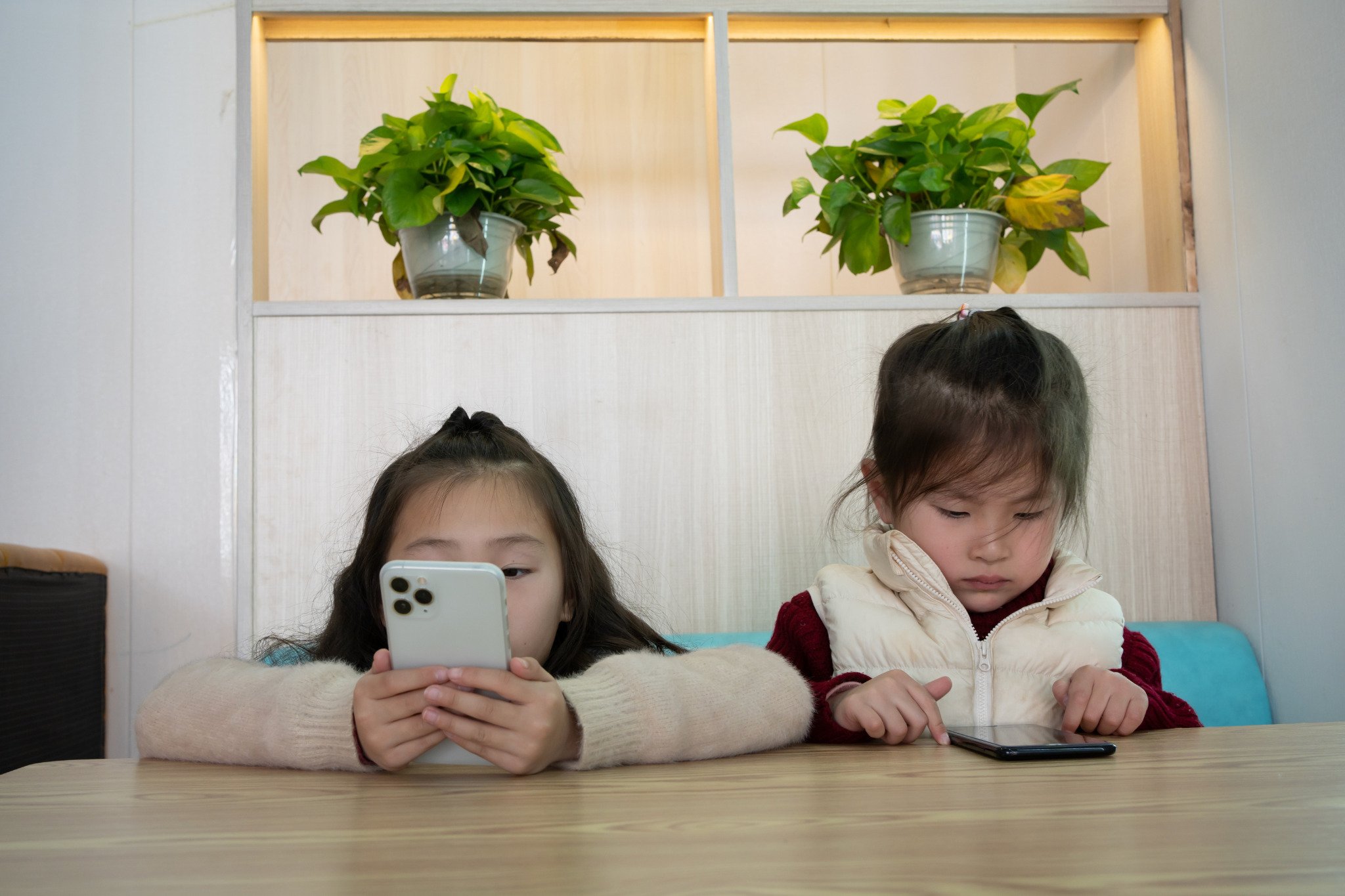  Trẻ có thể chơi điện thoại trong thời gian dài, với tư thế cúi đầu hàng giờ có thể gây tổn thương cho đốt sống cổ và cơ lưng (Ảnh minh hoạ)