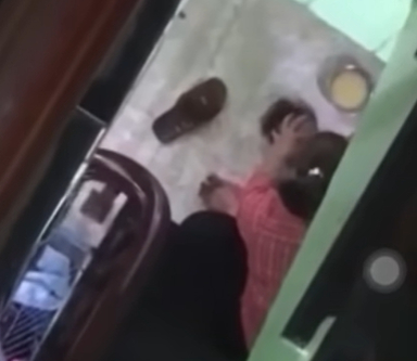  Trẻ bị đè dưới sàn nhà, bị đánh liên tục vào đầu để ép ăn - Ảnh cắt từ clip