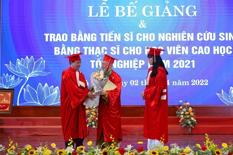  Ông Vương Tấn Việt (người đứng ở giữa) nhận bằng tiến sĩ năm 2022 