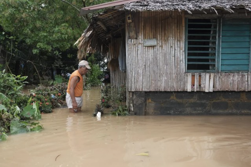  Người dân lội nước bên ngoài ngôi nhà ở tỉnh Albay, Philippines vào ngày 23/10/2024. Ảnh: AP