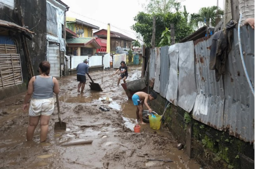  Người dân Philippines dọn dẹp bùn đất sau lũ do ảnh hưởng của bão Trami