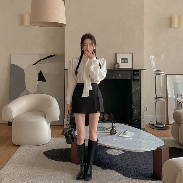  Áo blouse cổ nơ nên mix với chân váy ngắn và boots cao cổ.