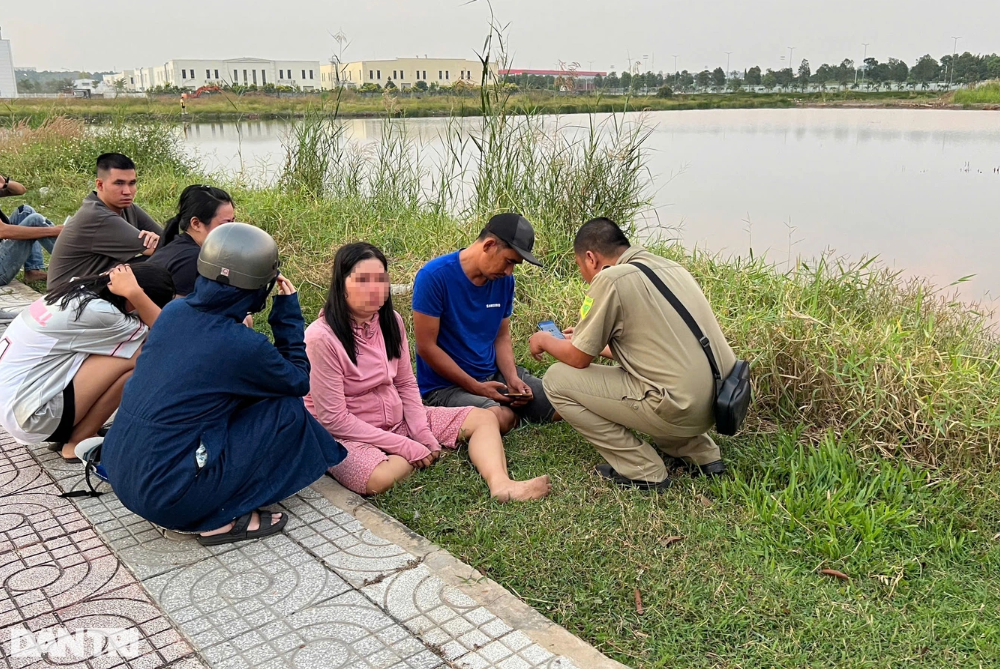  Mẹ bé trai ngồi thất thần tại khu vực hồ nước con trai gặp nạn - Ảnh: Báo Dân trí