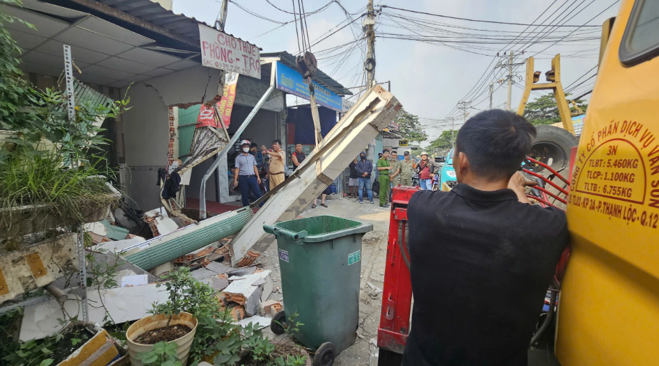  Các mảng tường gạch, trụ bê tông nhà dân bị xe taxi công nghệ tông bể nằm ngổn ngang - Ảnh: Báo Thanh Niên