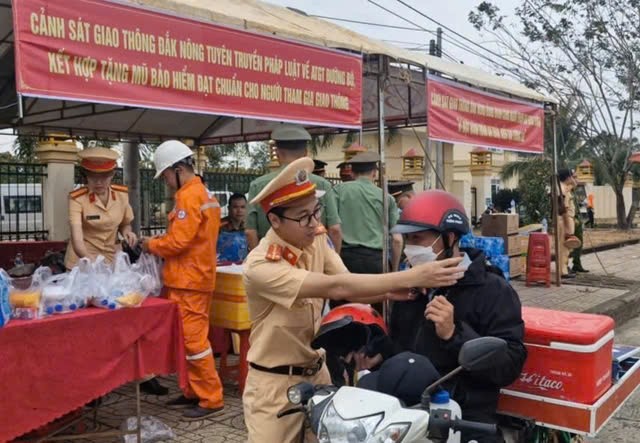   Người dân về quê ăn Tết được lực lượng CSGT đổi mũ bảo hiểm cũ lấy mũ bảo hiểm mới