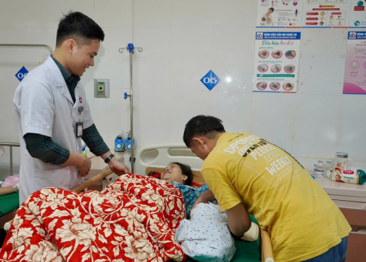 Vợ chồng chị H. được các bác sĩ Bệnh viện Sản Nhi Nghệ An hỗ trợ trong chăm sóc bé - Ảnh: Báo Nghệ An