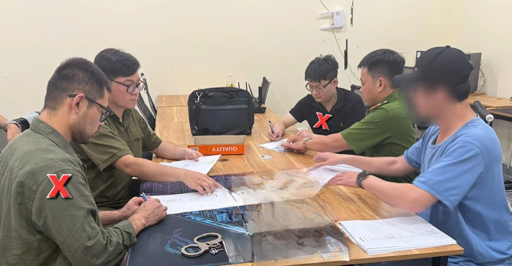 Công an làm việc với hai thành viên nhóm lừa đảo do Xing cầm đầu - Ảnh: Báo Tuổi Trẻ