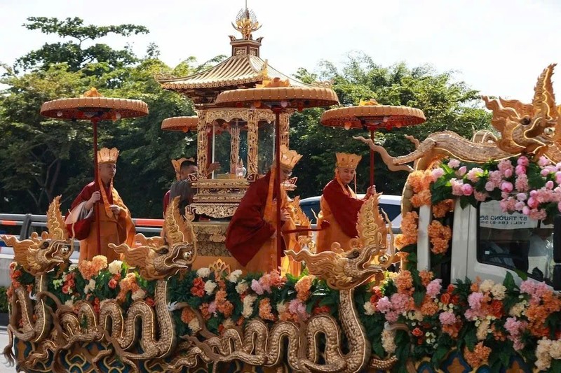Xe chở Xá lợi Đức Phật được trang trí hình rồng uốn lượn và hoa. Bảo vật được đặt trong hộp kính có đỉnh tháp. Bốn sư thầy đứng xung quanh, cầm ô tháp tùng Xá lợi.
