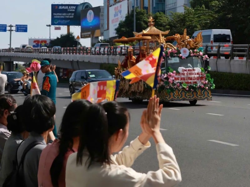 Bên ngoài sân bay, nhiều phật tử mang cờ Phật giáo, hoa cúc trắng, sen chờ ở đường Trường Sơn, quận Tân Bình.