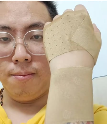 Suốt ngày phải bế con khiến anh bị viêm khớp. Ảnh: Baidu.