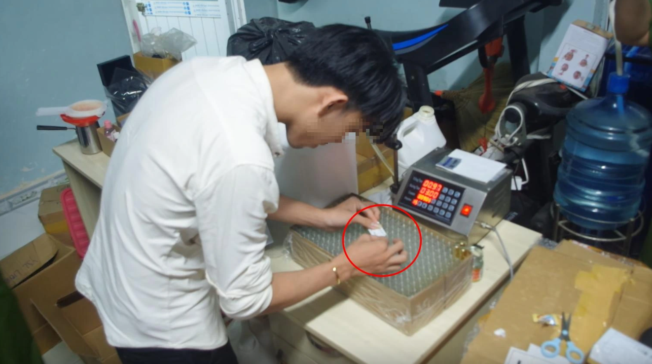 Từ can lớn, nước hoa giả được sang chiết vào các chai nhỏ, sau đó dán nhãn, đóng hộp và rao bán trên mạng xã hội - Ảnh: Báo Thanh Niên