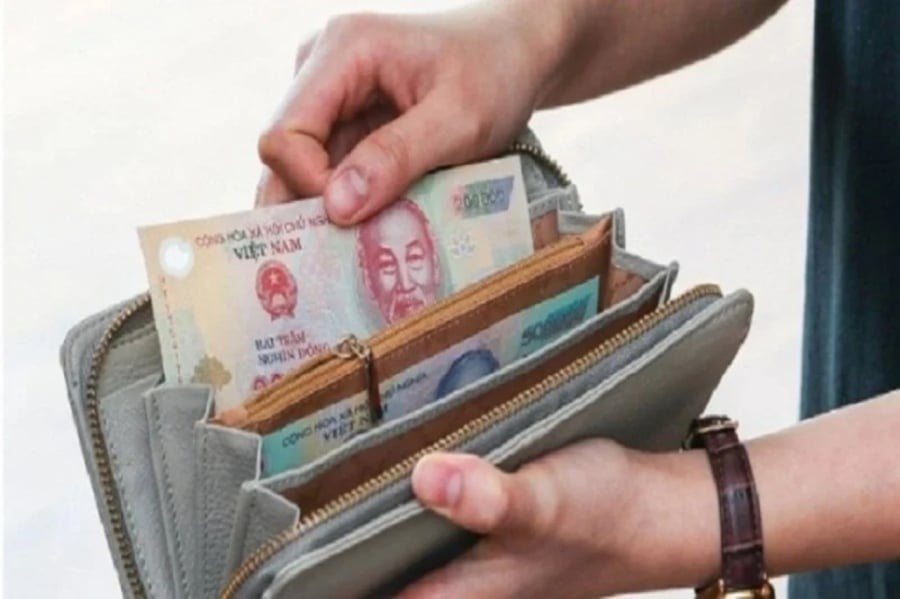 Bỏ tiền giấy vào ví. (Ảnh minh họa)