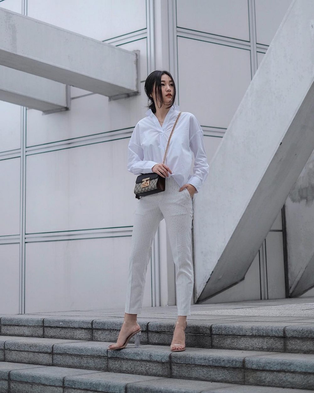 Áo sơ mi trắng phối cùng quần dài kẻ sọc vừa giúp bạn ăn gian chiều cao kèm thêm đôi guốc quai trong hot hit từ năm ngoái sang năm nay cực kỳ trendy.