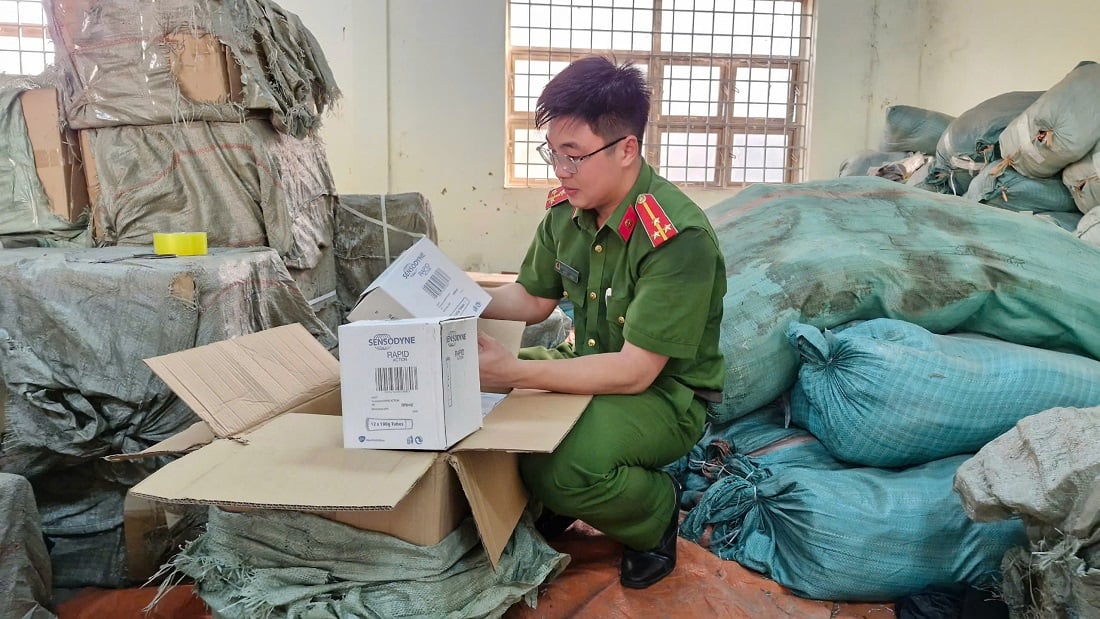 Cán bộ Công an tỉnh Nghệ An kiểm tra số kem đánh răng, dầu gội, nước xả vải giả mạo các nhãn hiệu… được thu giữ trong chuyên án - Ảnh: Báo Lao Động