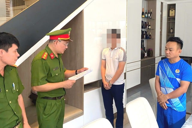 Cơ quan công an thi hành lệnh khám xét nhà đối tượng Nguyễn Văn Vinh (người mặc áo thun màu xanh)