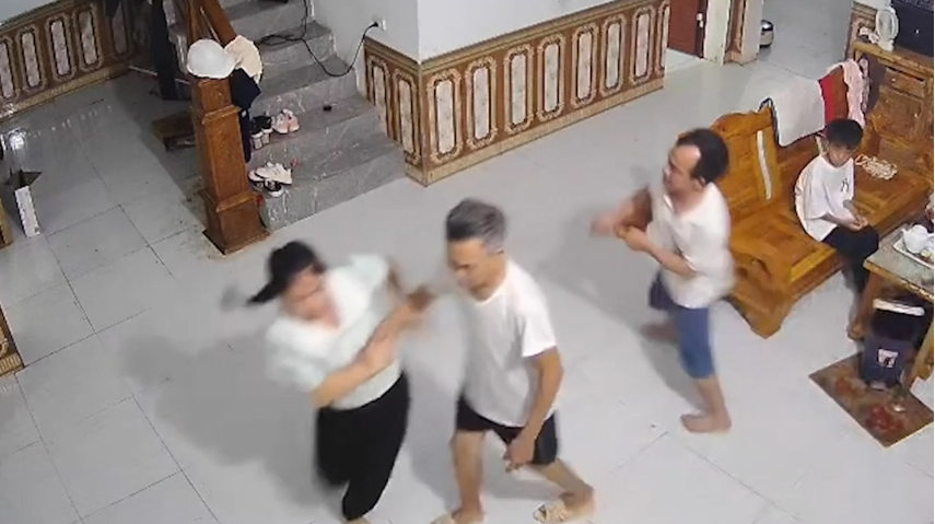 Người chồng dùng cán chổi hành hung vợ ngay trước mặt con nhỏ - Ảnh: VietNamNet
