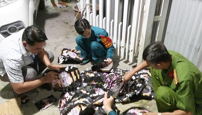 Lực lượng chức năng phát hiện số lượng lớn nguyên liệu, dụng cụ dùng để làm giả nước xả vải - Ảnh: Báo Tin tức thông tấn xã Việt Nam