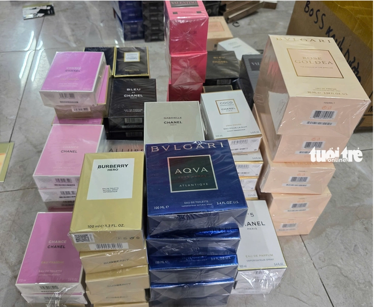Cơ quan công an thu giữ số lượng lớn nước hoa giả các thương hiệu nổi tiếng Chanel, Bvlgari, YSL… - Ảnh: Tuổi Trẻ Online