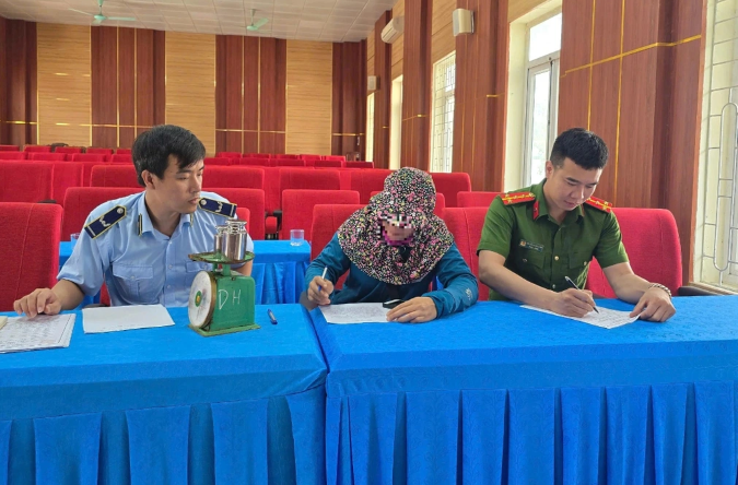 Cơ quan chức năng làm việc và xử phạt người phụ nữ bán hàng rong - Ảnh: Báo Dân trí
