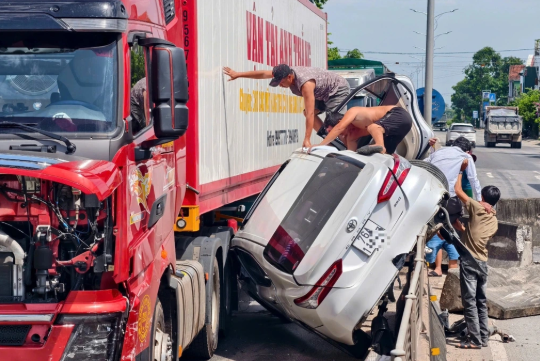 Người dân cứu 3 người trong ô tô gặp nạn - Ảnh: Báo Dân trí
