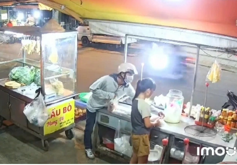  Camera ghi lại người đàn ông dàn cảnh mua đồ, lấy tiền bé gái bỏ chạy - Ảnh: Báo Thanh Niên