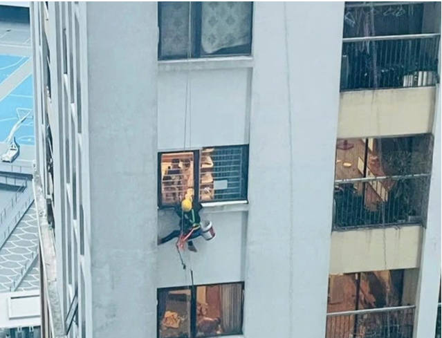 Chàng thợ sơn được đưa vào bên trong qua cửa sổ tránh nguy hiểm - Ảnh: Báo Dân trí