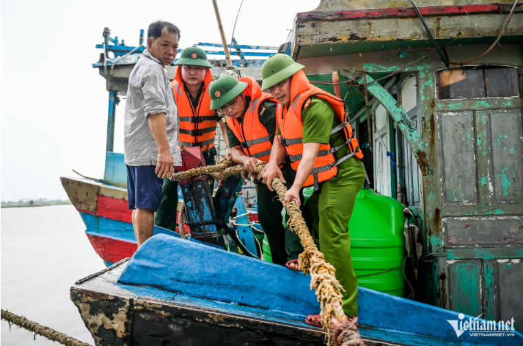 Lực lượng chức năng hỗ trợ ngư dân thu dọn ngư cụ, chằng buộc tàu thuyền - Ảnh: VietNamNet