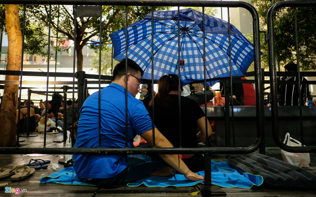 Đêm 20/9, sau gần một ngày chờ đợi, những người chờ mua iPhone XS hứng chịu một trận mưa rào.
