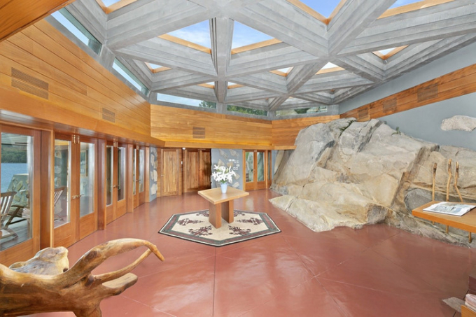 Một khối đá khổng lồ cao 1,1m. dài 5,5m được đặt bên trong kết hợp với đồ nội thất và cửa gỗ tạo nên vẻ hoang sơ, tự nhiên cho ngôi nhà.