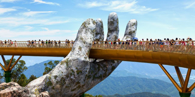 Cầu Vàng, Việt Nam: Cây cầu nằm trong khu vườn Thiên Thai thuộc Khu du lịch Bà Nà Hills, Đà Nẵng. Mặt cầu có chiều dài 150m và được nâng bởi hai bàn tay khổng lồ ở độ cao 1.400 so với mặt nước biển. “Đôi bàn tay” trông như có niên đại nhiều thế kỷ, nhưng chúng mới được xây dựng vào năm 2018.