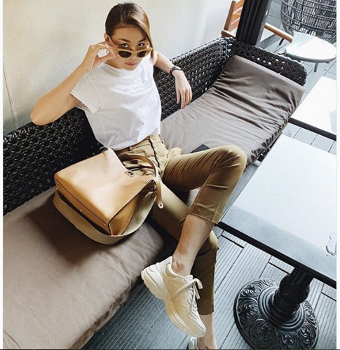 Siêu mẫu Thanh Hằng mặc đơn giản mà vẫn sành điệu với áo phông trắng, quần âu và giày thể thao. Ảnh: Instagram, FBNV.