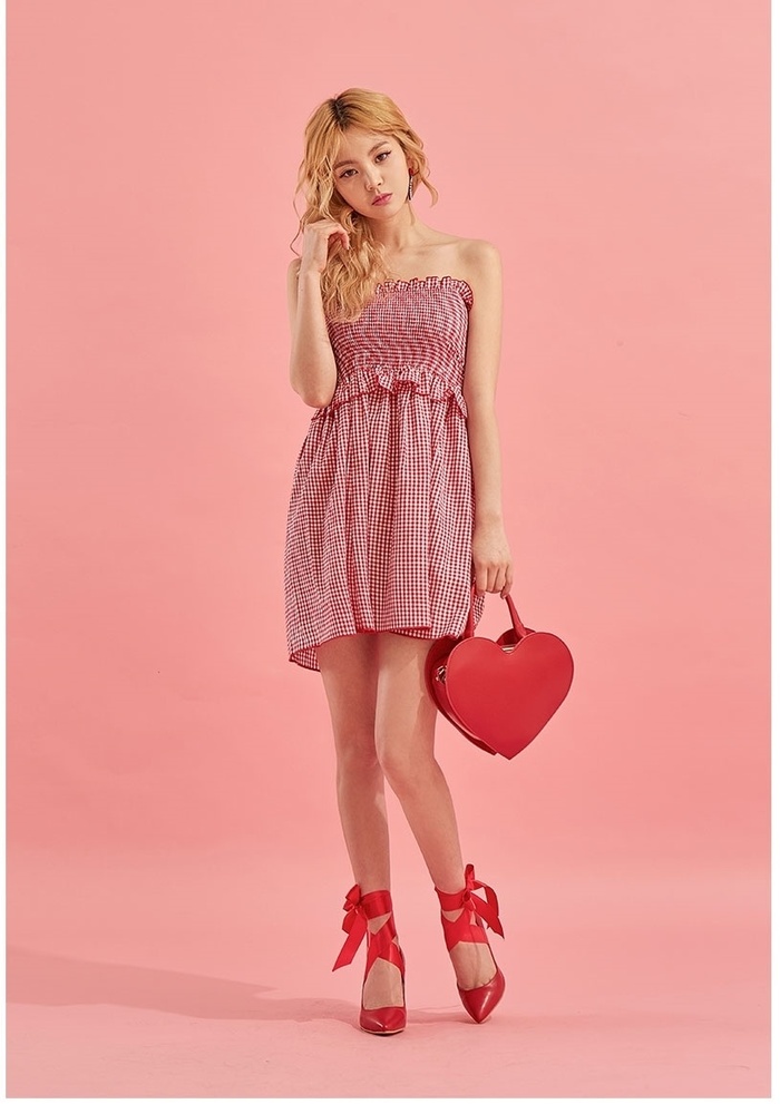 Váy trễ vai kẻ caro màu đỏ là trang phục hoàn hảo cho những ngày Tết ấm áp. Túi xách hình trái tim và giày cao gót buộc dây.  