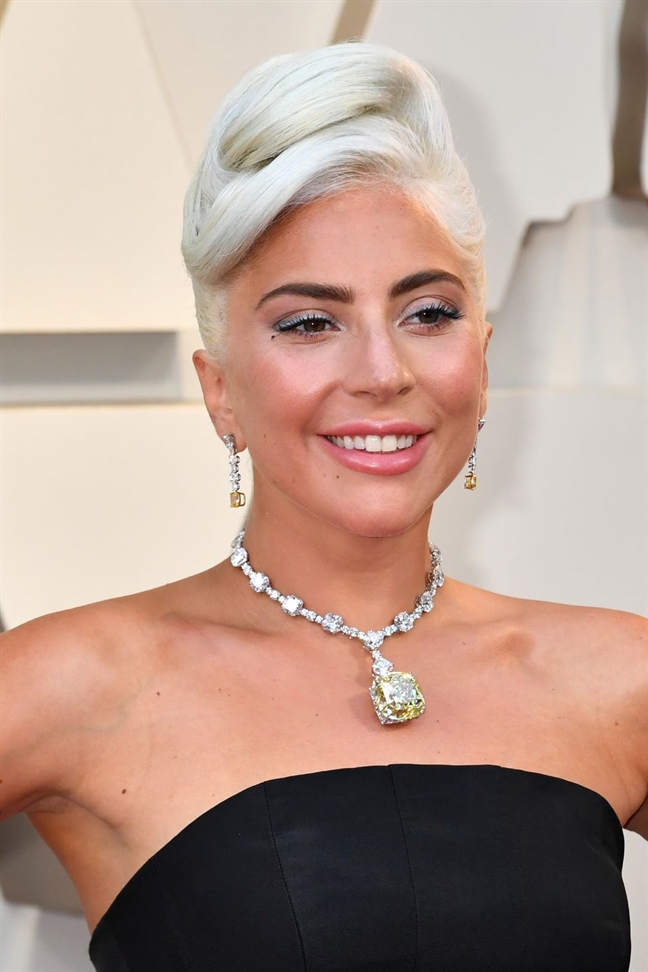 Lady Gaga xuất hiện thu hút tại thảm đỏ lễ trao giải Oscar lần thứ 92 với tóc bạch kim búi cao, nhô ở phần đỉnh đầu theo phong cách cổ điển. Tông màu son hồng nude và phần mắt màu xám khói khiến nữ ca sĩ càng thêm cuốn hút. 