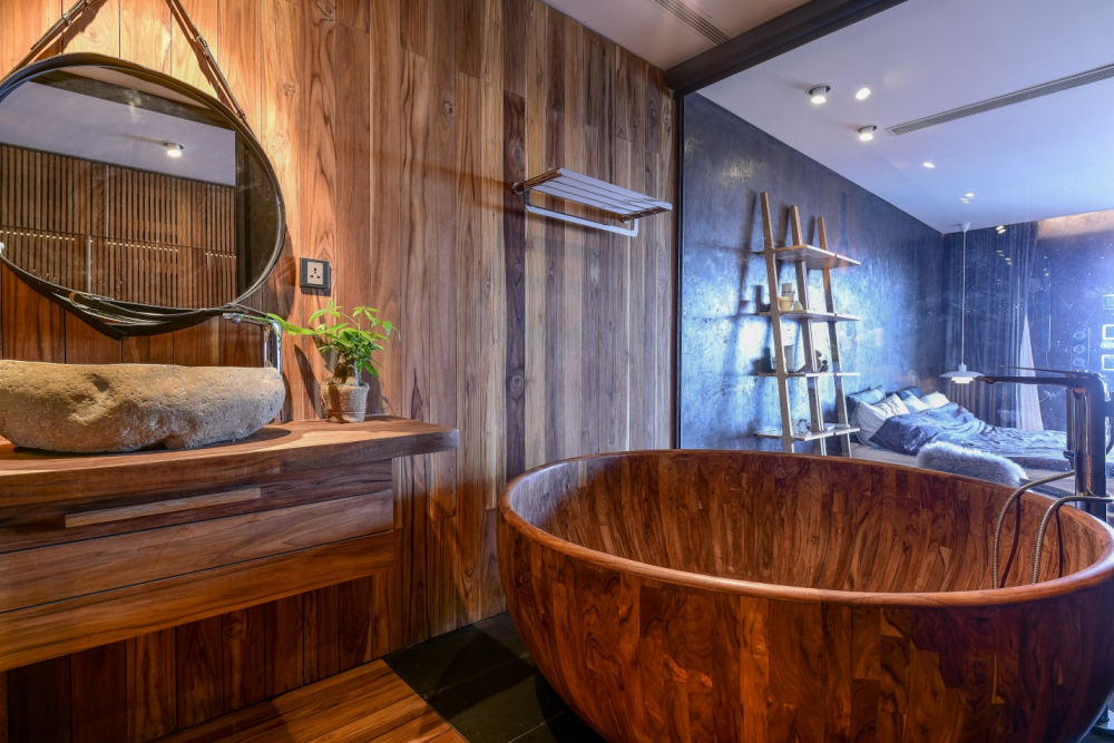 Điểm nhấn trong nhà vệ sinh của căn hộ là bồn tắm được làm bằng gỗ nguyên khối, kết hợp với màu trầm ấm của gỗ trong nội thất đem lại một cảm giác tối giản nhưng ấm cúng. 