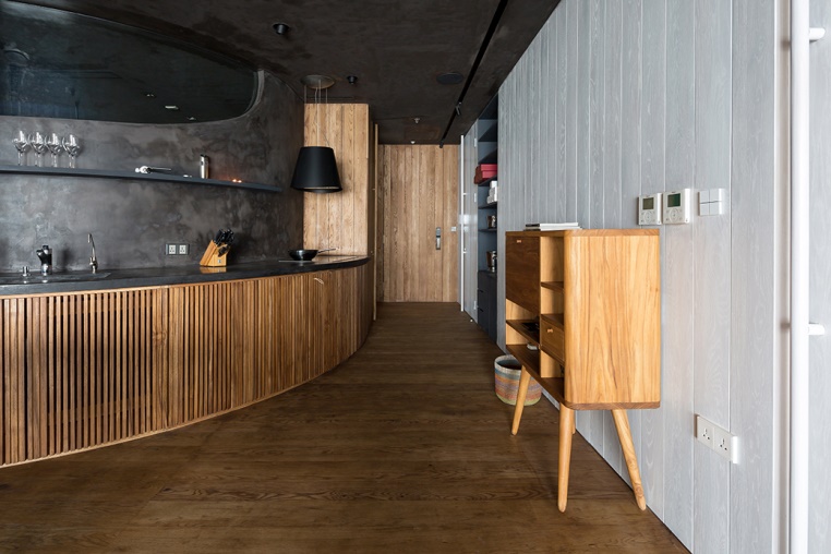 Để tận dụng không gian, khu bếp của hộ được thiết kế dạng vòng cung vừa mang lại sự mềm mại của căn nhà, vừa tạo thành 1 lối mòn đi vào rừng cây. 
