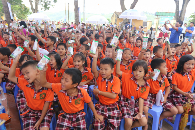 ác em học sinh Việt Nam hào hứng với ly sữa trên tay trong một buổi sinh hoạt tập thể