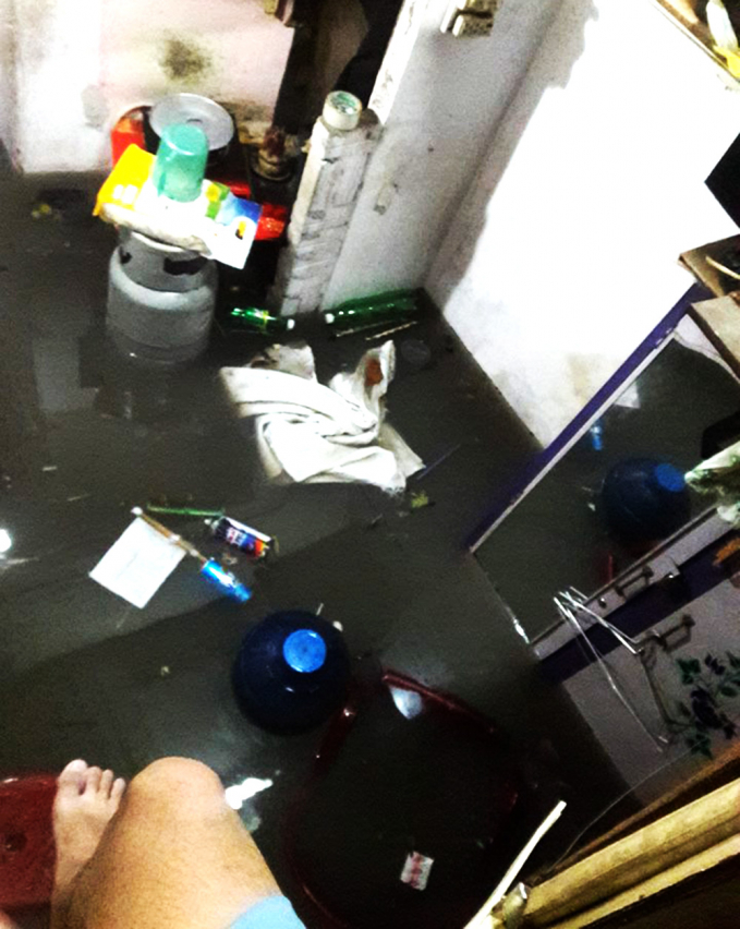 Nước đục ngầu tràn vào nhà, người dân không dám bước xuống vì quá bẩn. (Ảnh FB: Tạ Phú Nam).