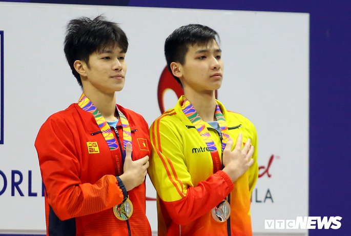  Kim Sơn (phải) và Hưng Nguyên đứng cạnh nhau hát Quốc ca khi nhận huy chương tại nội dung 400m hỗn hợp.
