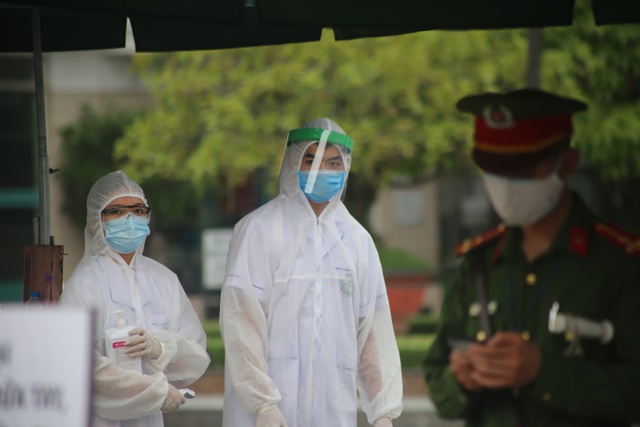  Hình ảnh các nhân viên y tế túc trực tại cổng Bệnh viện Bạch Mai để thực hiện kiểm tra y tế đối với người ra, vào (Ảnh: Nguyễn Trường).